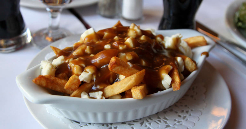 Close Up Photo Of Poutine In A White Plate
