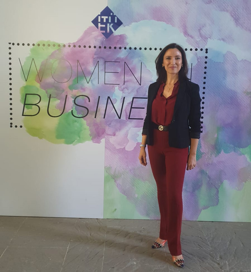 Irem Tuzunalper Standing In Front Of Sign Women In Business