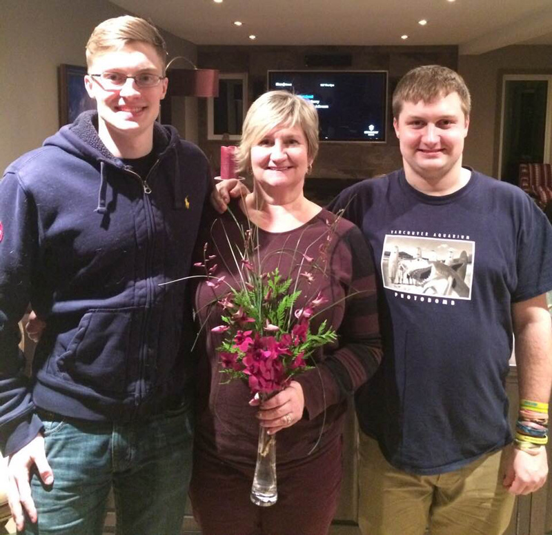 Kellie Garrett Holding Flower In Vase With Her Sons Max And Connor