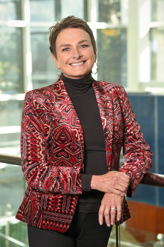 Smiling Pam Klein In Red Pattern Jacket Corporate Photo