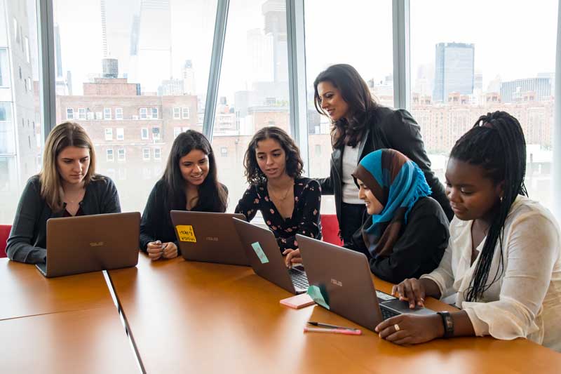 Reshma Saujani Standing Over Class Room And Looking At Computers Screens Students Of Girls Who Code Students 