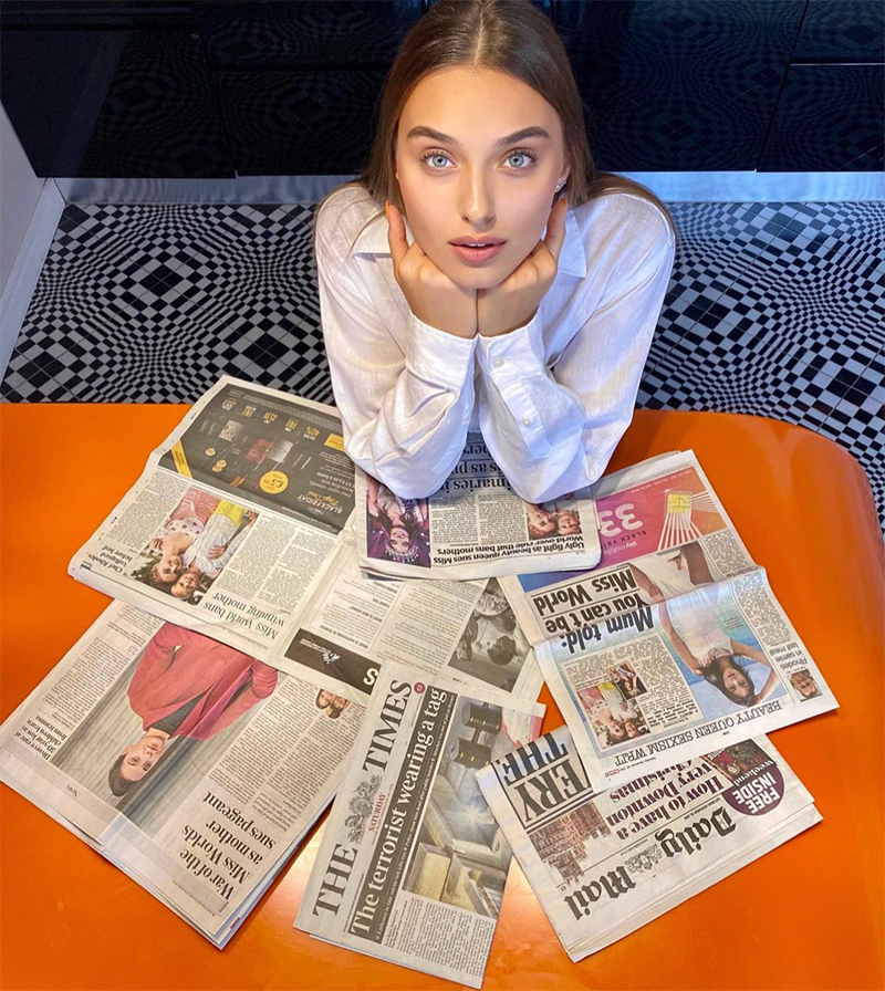 Veronika Didusensko Looking At Camera Surrounded By Newspapers With Her Story On Them