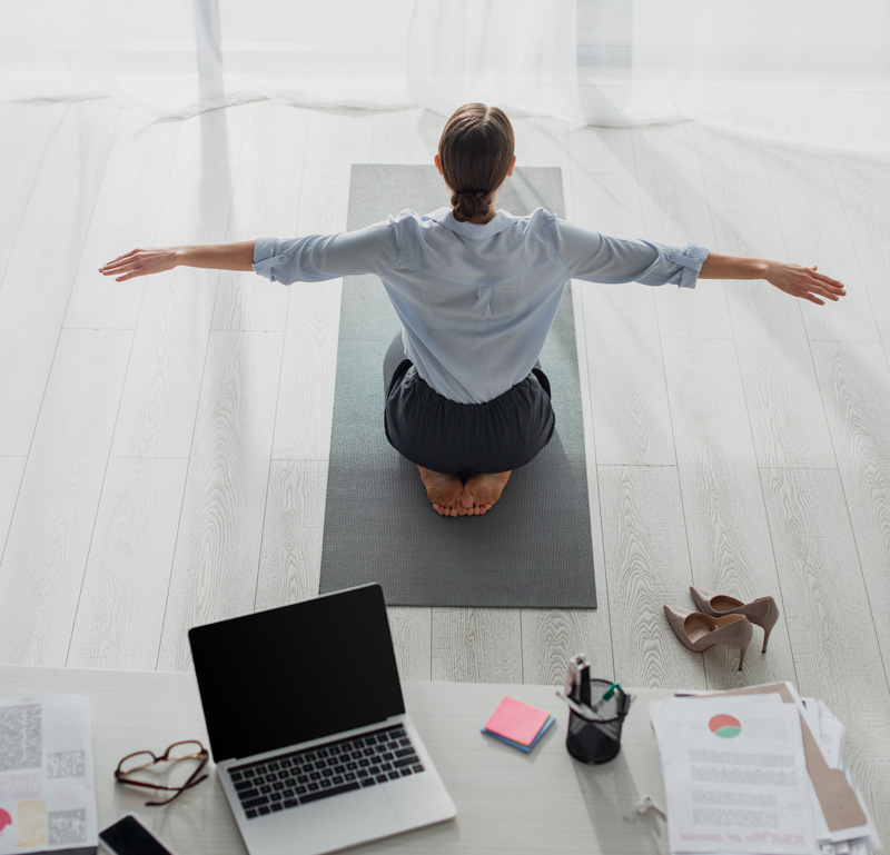 Woman On Knees Doing Yoga In Office Setting